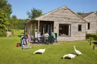Mensen zitten op het terras bij hun eigen bungalow